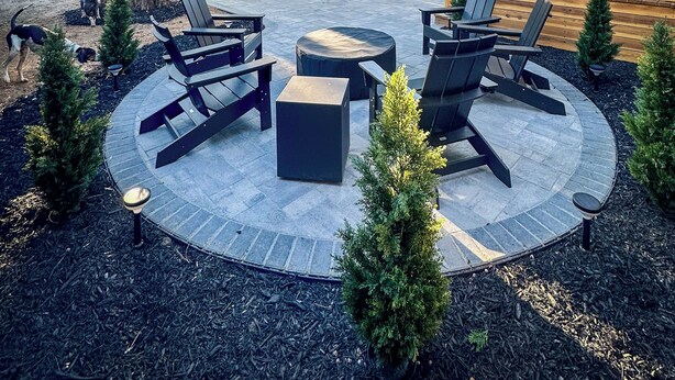 A cabin with a deck, outdoor seating, and a fire pit.