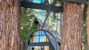 A cabin with a wooden exterior, a large window, and a door with the number 1024.
