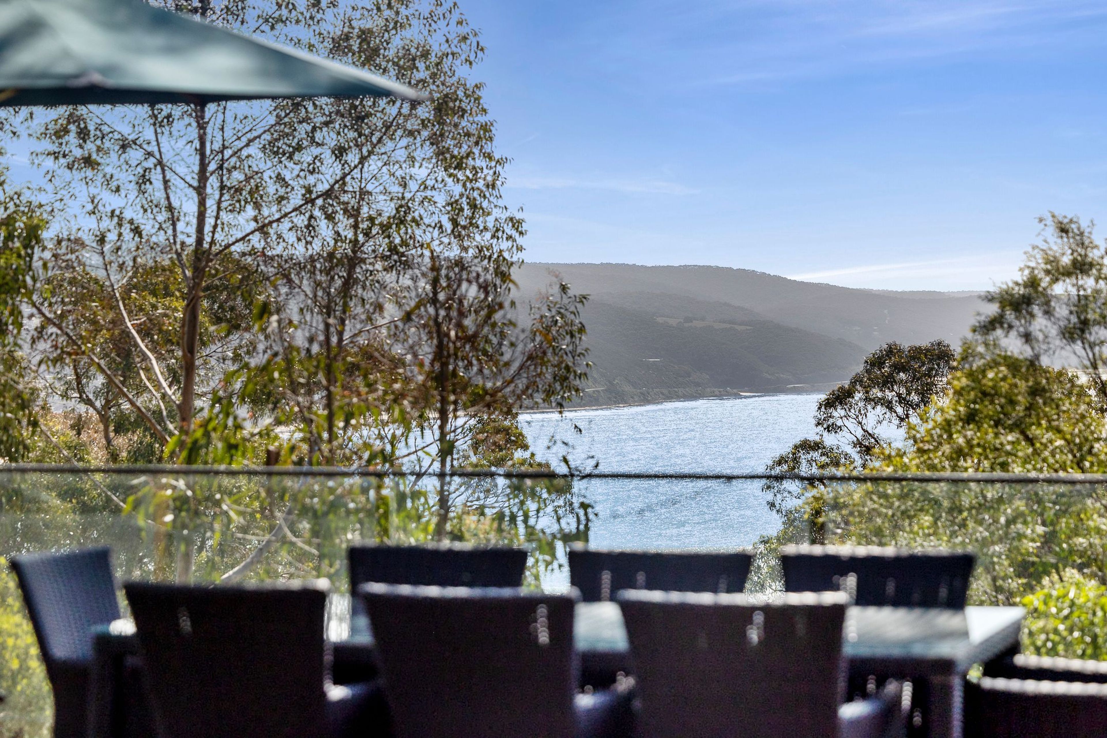 Un espacio de estar al aire libre con vistas a un cuerpo de agua y colinas.
