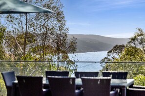 Un espacio de estar al aire libre con vistas a un cuerpo de agua y colinas.