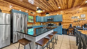 Una cocina moderna con una isla central, electrodomésticos de acero inoxidable y armarios azules.