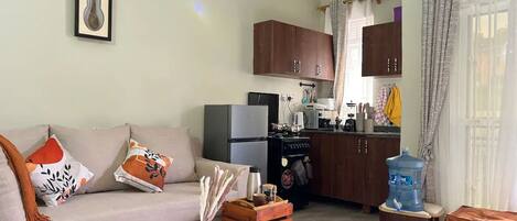 Una sala de estar con sofá, mesa de centro y un cuadro en la pared.