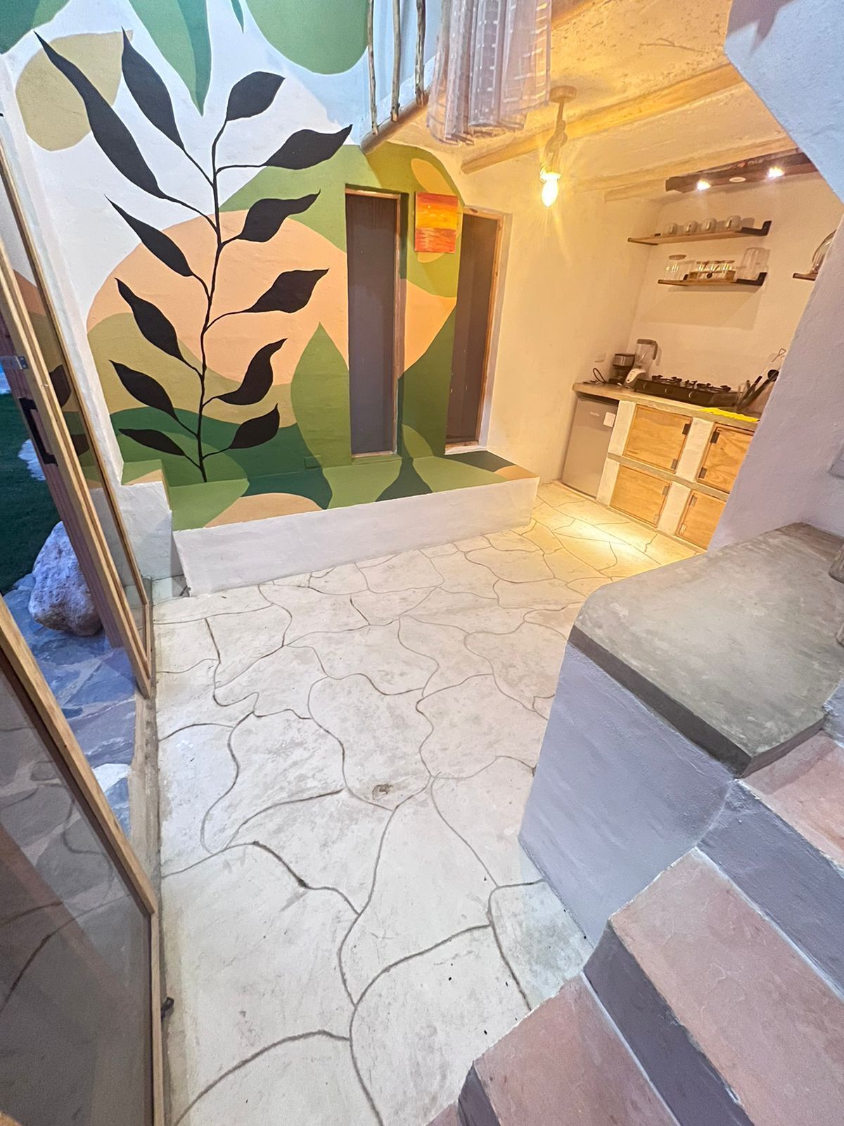 Eine Treppe führt zu einer Küchenzeile mit modernem Design, inklusive Arbeitsplatte und Herd.