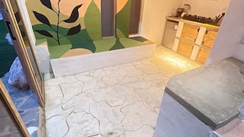 Eine Treppe führt zu einer Küchenzeile mit modernem Design, inklusive Arbeitsplatte und Herd.