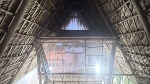 Una habitación con techo de paja y vistas al exterior.