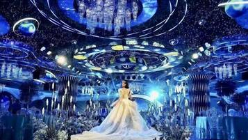 A futuristic interior with a central circular platform and a person in a white dress.
