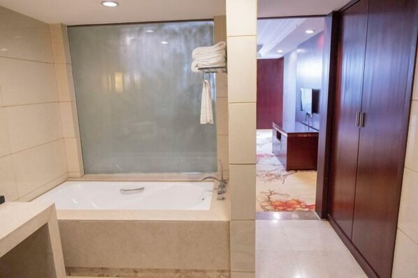 A bathroom with a bathtub, a glass shower enclosure, and a vanity with a mirror.