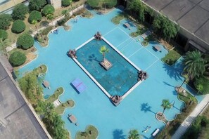 Vista aérea de una piscina rodeada de áreas ajardinadas y árboles.