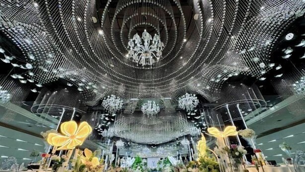 A spacious interior with a central aisle, decorative chandeliers, and floral arrangements. - Baili Hotel (Changshan)