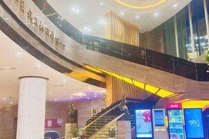 Un espacio interior de varios niveles con una escalera central, barandillas de vidrio y quioscos informativos digitales.