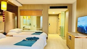 A hotel room with two beds, a TV, a mirror, and a bathroom visible through a sliding door. - Baili Hotel (Changshan)