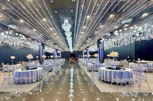 Un salón de banquetes con mesas redondas, candelabros y suelo reflectante.