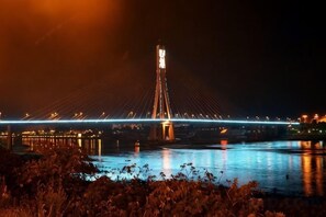 A nighttime view of a bridge with lights reflecting on the water. - Shengchang Hotel (Xishuangbanna Gaozhuang Xishuangjing Branch) (Jinghong)