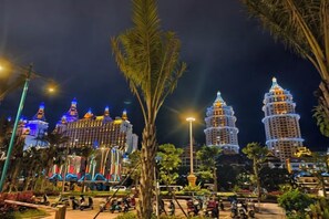 A night view of a hotel with illuminated towers and a well-lit garden area. - Shengchang Hotel (Xishuangbanna Gaozhuang Xishuangjing Branch) (Jinghong)
