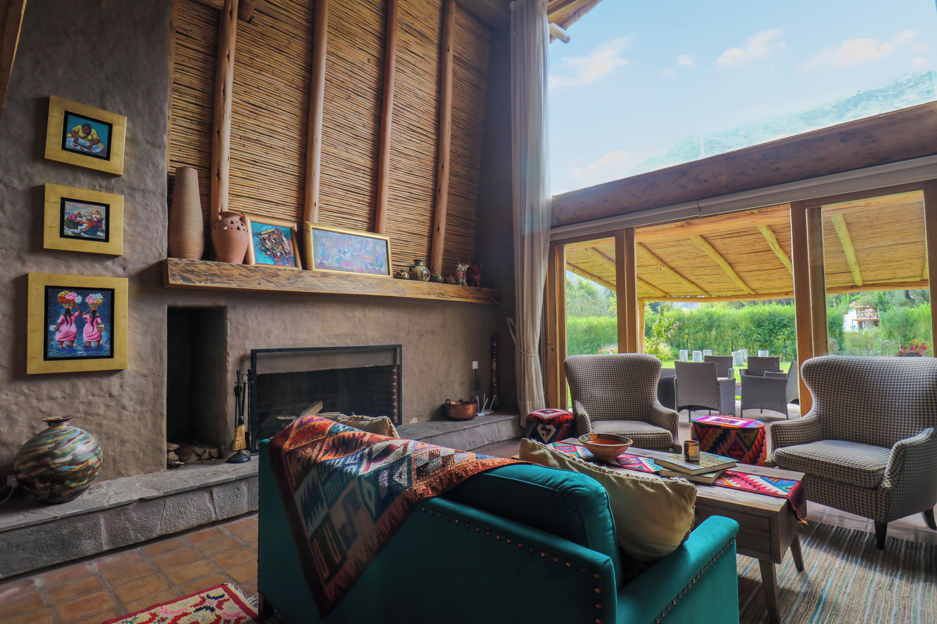 Una sala de estar acogedora con chimenea, asientos cómodos y grandes ventanales que ofrecen vistas al exterior.