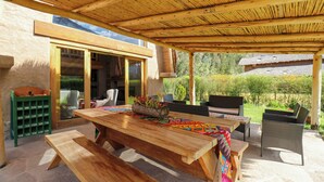 An outdoor wooden dining area with a table, benches, and chairs. - Mayupata in Calca by Wynwood House (Calca)
