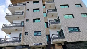 Un edificio a più piani con balconi e un cartello che riporta la scritta "T-SQUARE".