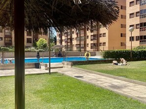 A residential building with a swimming pool, a covered patio area, and a grassy lawn. - campezo (Madrid)