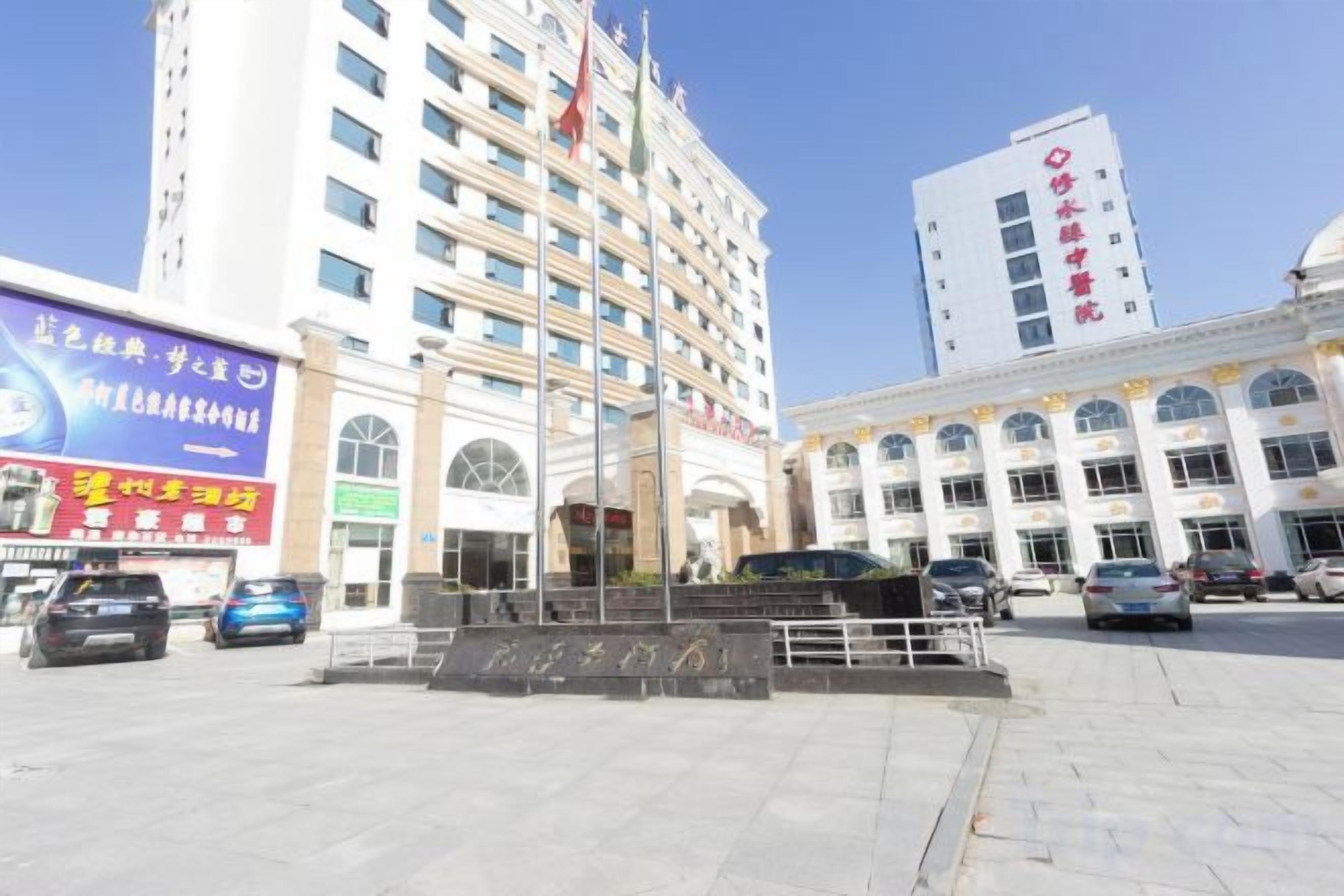 A hotel with a central entrance, multiple floors, and a flagpole.