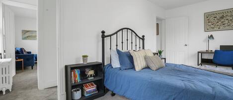 Une chambre à coucher avec un lit, une bibliothèque, un bureau et une chaise.
