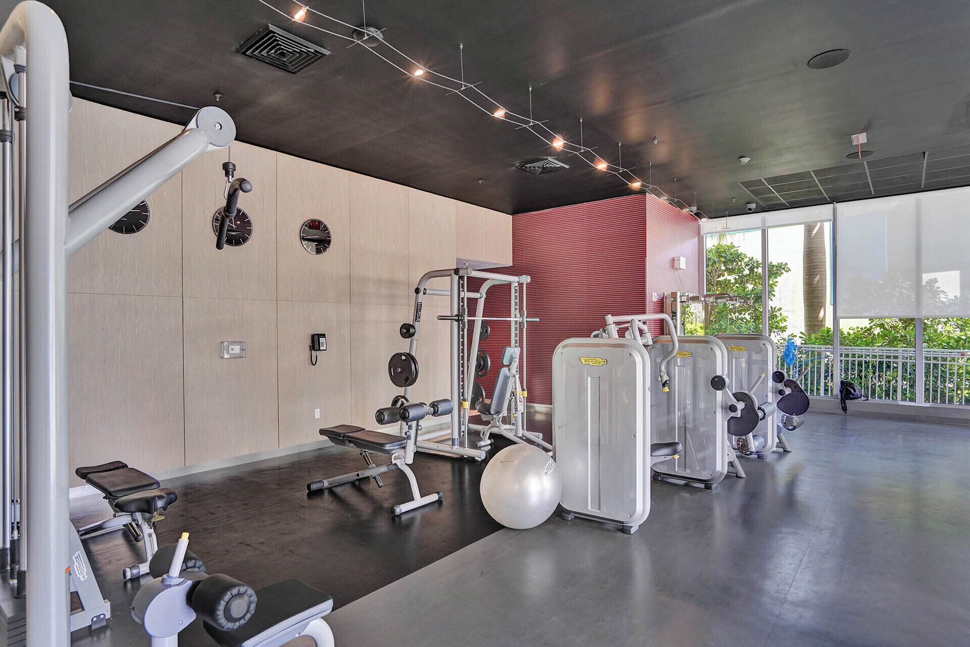 A modern gym with various exercise equipment, including weight machines and free weights.