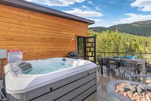 A wooden cabin with a hot tub, outdoor seating, and a sign indicating spa rules. - Whitefish Slopes / Ski-In/Out, Hot Tub & Rooftop (Whitefish)