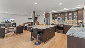 A modern kitchen with dark wood cabinets, granite countertops, and stainless steel appliances. - Ski Chalet • 4 bedroom • Beautifully Remodeled • Walk to Lifts (Park City)