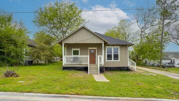 A single-story house with a front porch, a small front yard, and a clear sky.