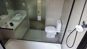 A modern bathroom with a glass-enclosed shower, a white bathtub, and a toilet. - Hotel Maravilha do Lago (Pedregulho)