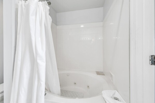 A white bathroom with a bathtub, a shower curtain, and a toilet. - 🦩Book Me Baby! Pelican Isle #604 Penthouse Paradise 🦩 (Fort Walton Beach)