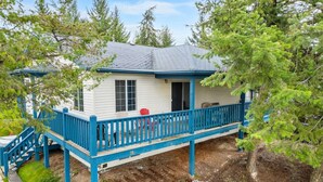 Een gelijkvloers huis met een blauwe veranda en een klein terras.
