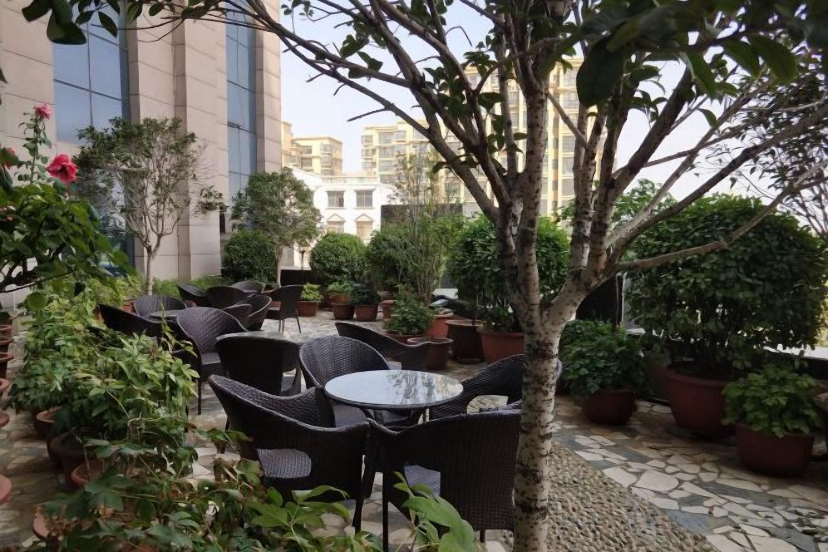 An outdoor seating area with wicker furniture and potted plants.