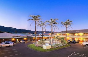 A hotel with a parking lot, multiple buildings, and palm trees. - Apollo Bay Motel & Apartments (Apollo Bay)
