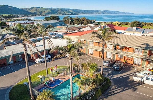 A hotel with a swimming pool, a parking lot, and a view of the ocean. - Apollo Bay Motel & Apartments (Apollo Bay)