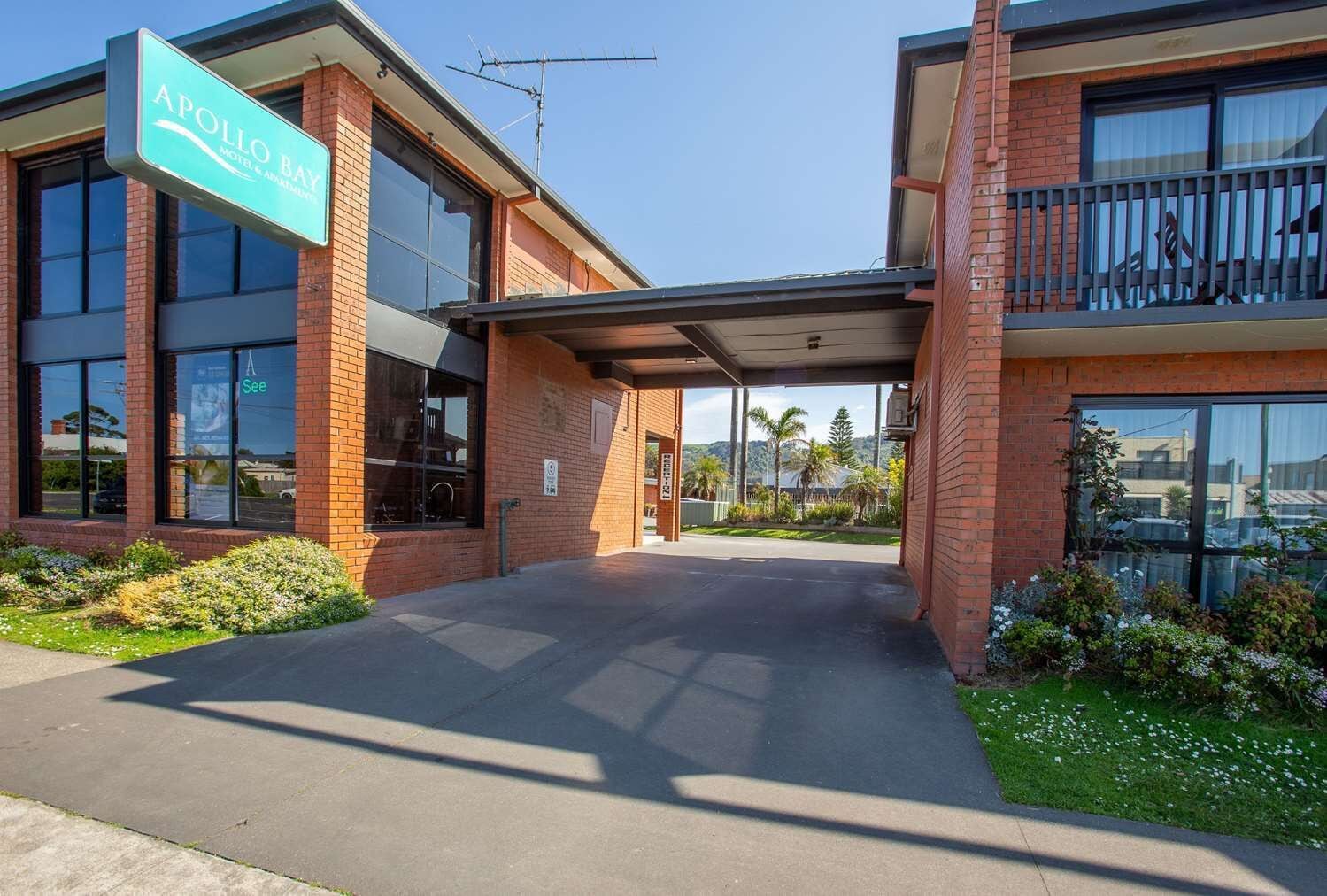 A two-story building with a sign reading 'Apollo Bay Motel & Apartments.'