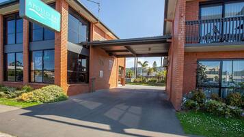 A two-story building with a sign reading 'Apollo Bay Motel & Apartments.'