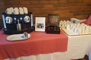 A coffee station with multiple coffee makers, a menu, and a variety of coffee cups and saucers. - Apollo Bay Motel & Apartments (Apollo Bay)