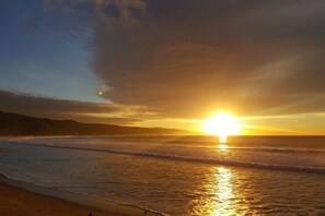 A sunset over a beach with waves. - Apollo Bay Motel & Apartments (Apollo Bay)