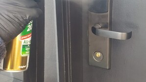 A person using a spray bottle on a door lock. - Apollo Bay Motel & Apartments (Apollo Bay)