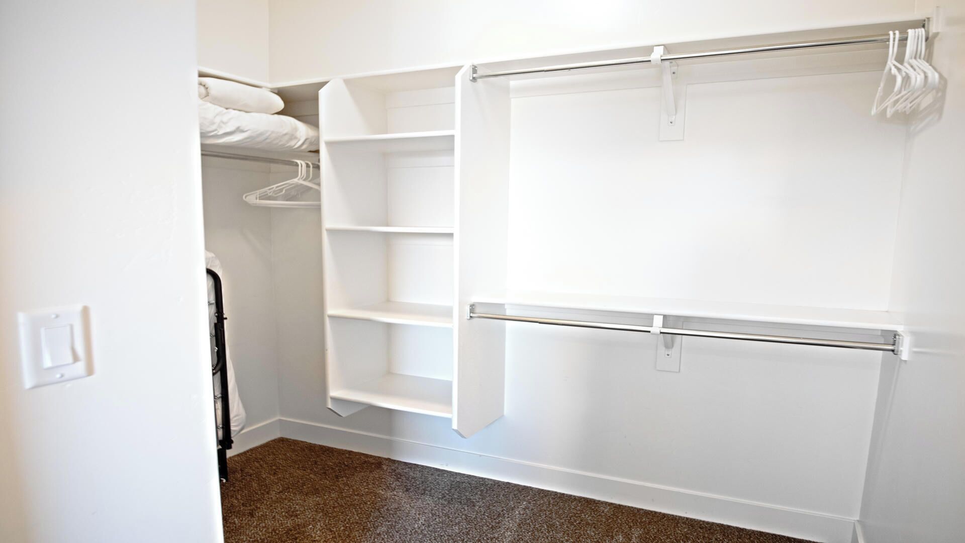 A walk-in closet with open shelves and hanging space.