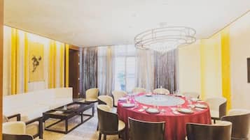 A dining area with a round table, chairs, and a chandelier.