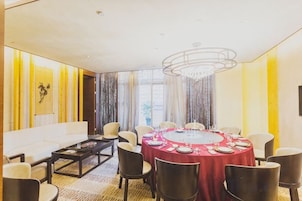 Un comedor con una mesa redonda, sillas y un candelabro.