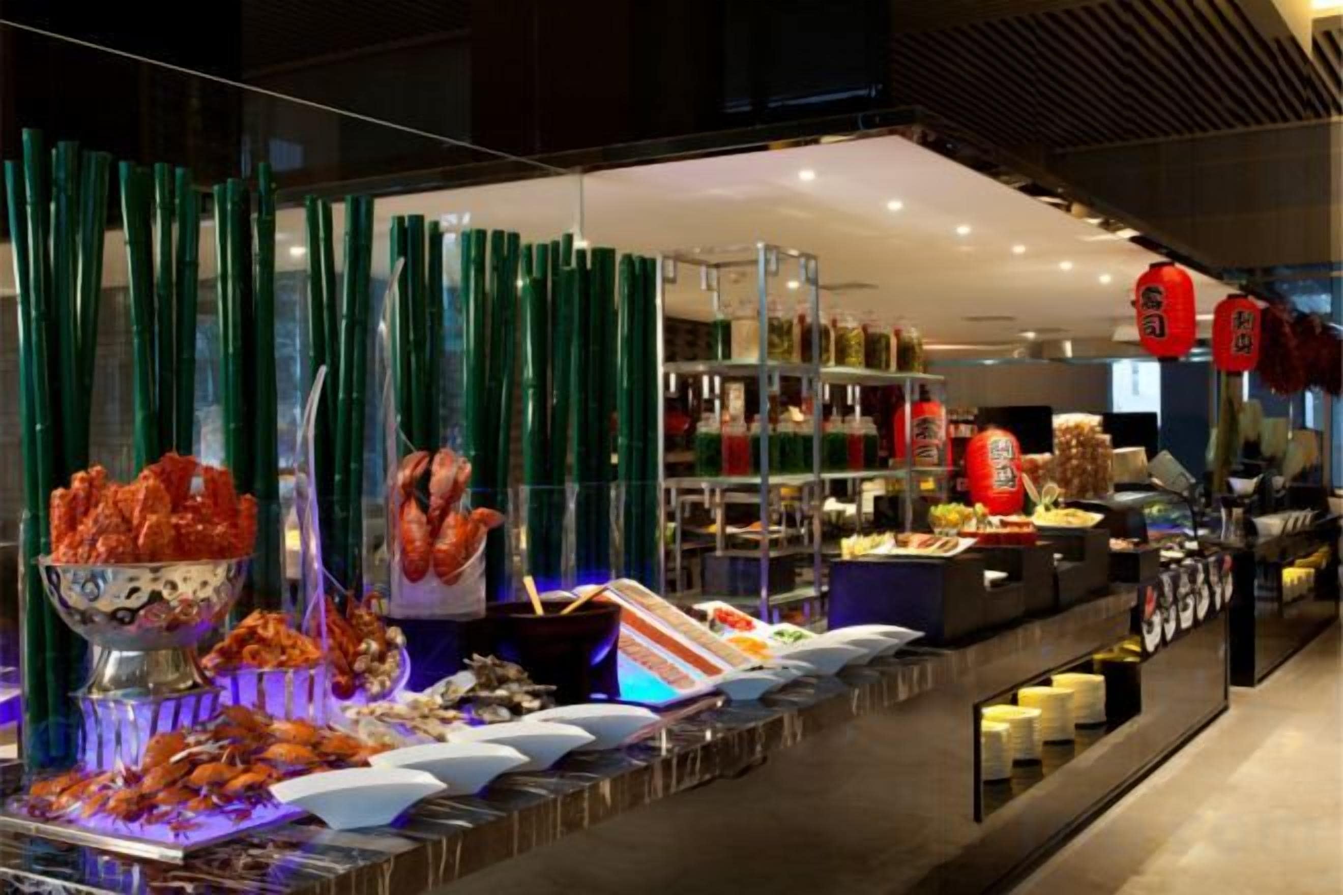 A buffet with various food items and a bartender area.