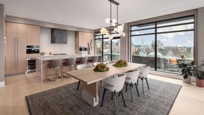 Une cuisine moderne avec un coin repas, de grandes fenêtres et une vue sur la ville.