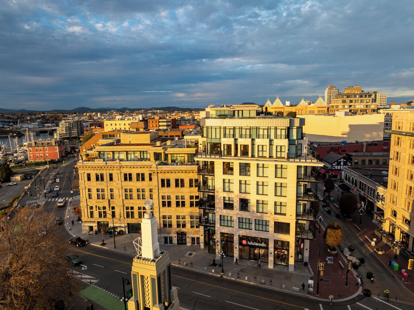 A cityscape with modern buildings, a prominent clock tower, and a busy street.