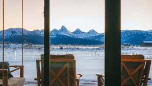 A room with a view of snow-covered mountains and a wooden swing set. - Basecamp Stays: Lux Retreat, Teton Views, 3 Acres! (Tetonia)