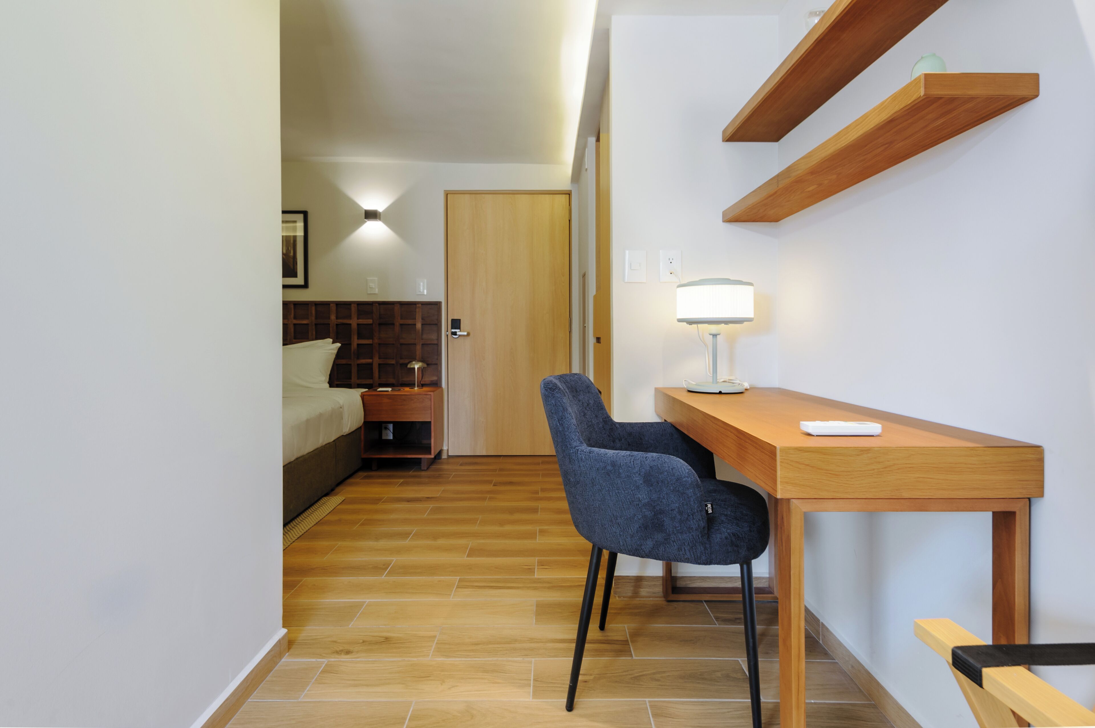 A compact room with a bed, a desk, and a chair.