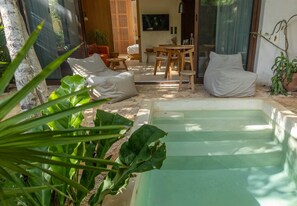 Un espace piscine comprenant un transat, une petite table et un canapé.