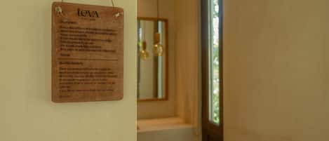 A wooden sign with text in English and Spanish, hanging on a wall.