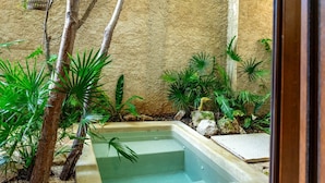 A small, rectangular pool with clear water, surrounded by various green plants and rocks. - Room with Private Pool and Garden |• TEVA 2B (Tulum)